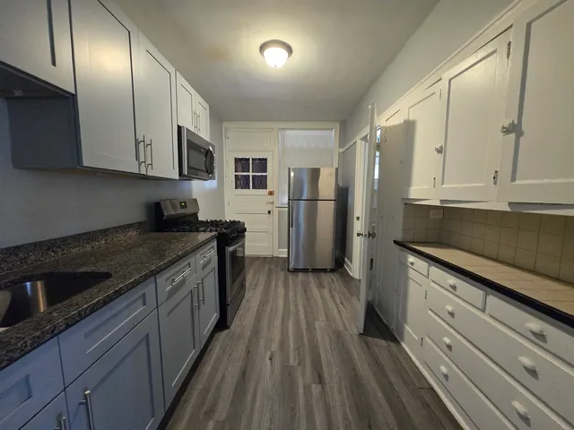 a kitchen with stainless steel appliances granite countertop a stove a sink and a refrigerator