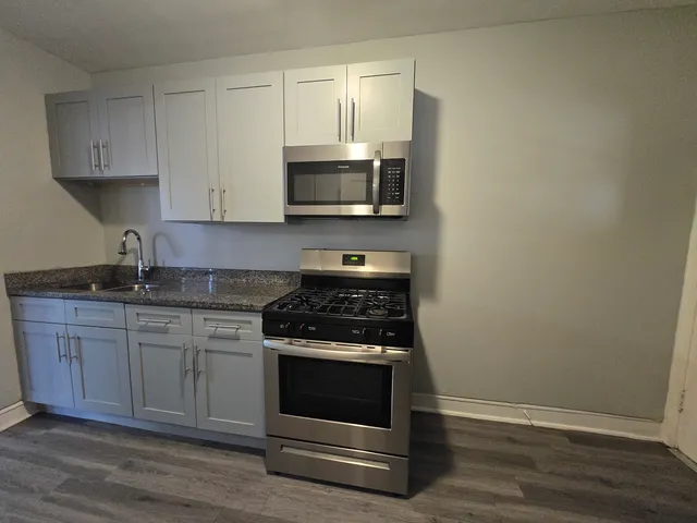 a kitchen with granite countertop a stove and a sink