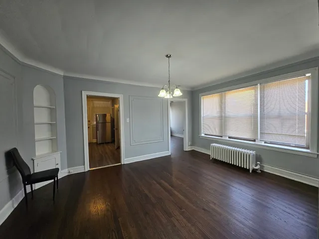 a view of a room with wooden floor fan and windows
