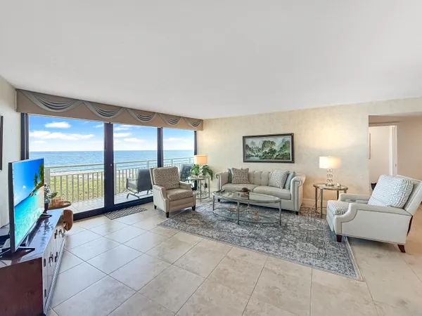 a living room with furniture and a floor to ceiling window