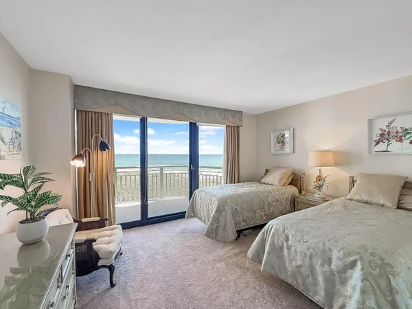 a bedroom with two beds and a large window