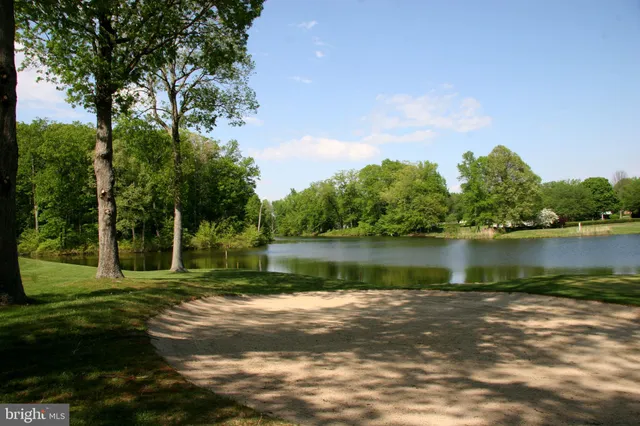 a backyard of a house with lots of green space and lake view