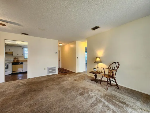a view of a livingroom with furniture and a kitchen