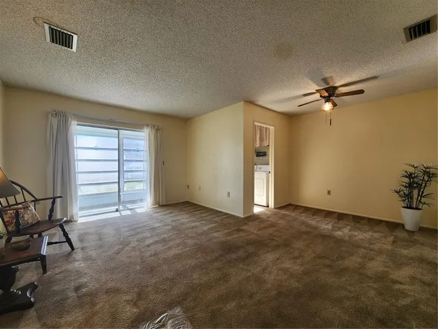 a view of a livingroom with a ceiling fan and window