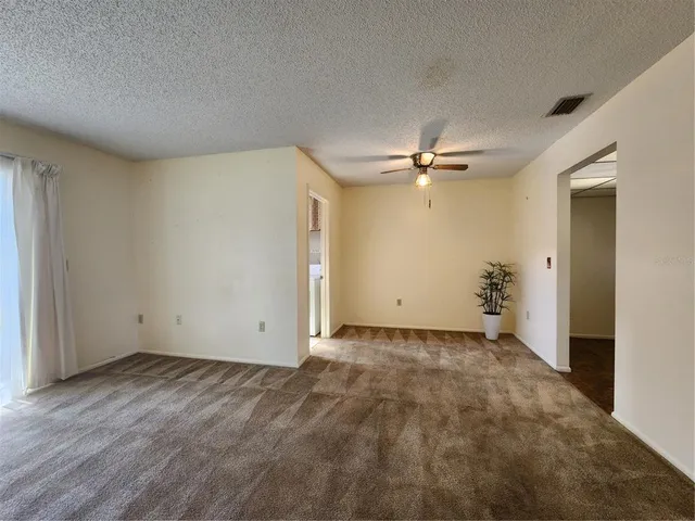 a view of a livingroom with a ceiling fan and window