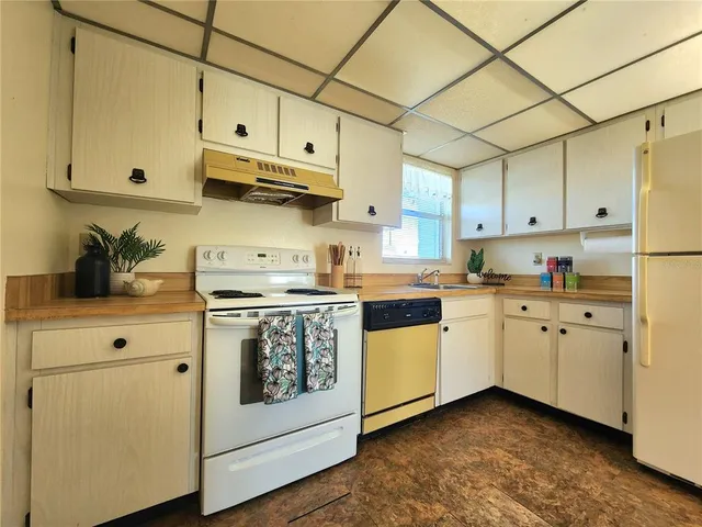 a kitchen with cabinets appliances a sink and a counter top