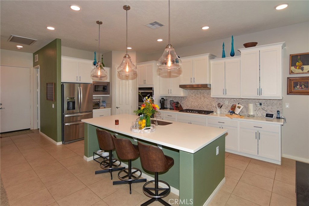 19520 Arcata Road Apple Valley, CA 92307 - Photo 12 of 53 a kitchen with kitchen island granite countertop a sink a center island stainless steel appliances and cabinets