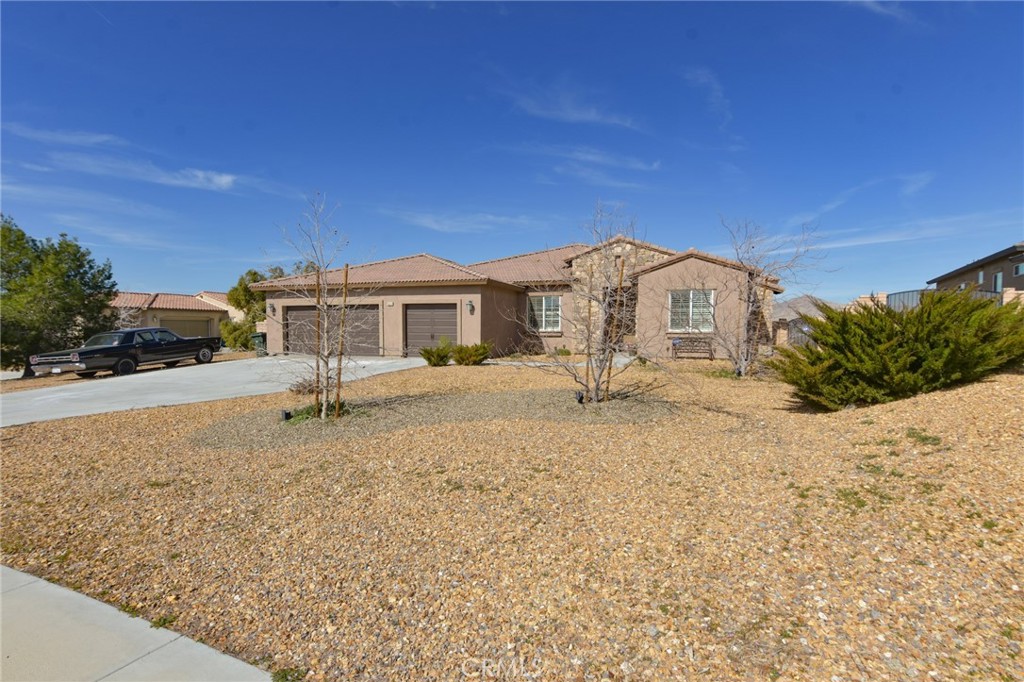 19520 Arcata Road Apple Valley, CA 92307 - Photo 3 of 53 a front view of a house with a yard covered with snow and trees