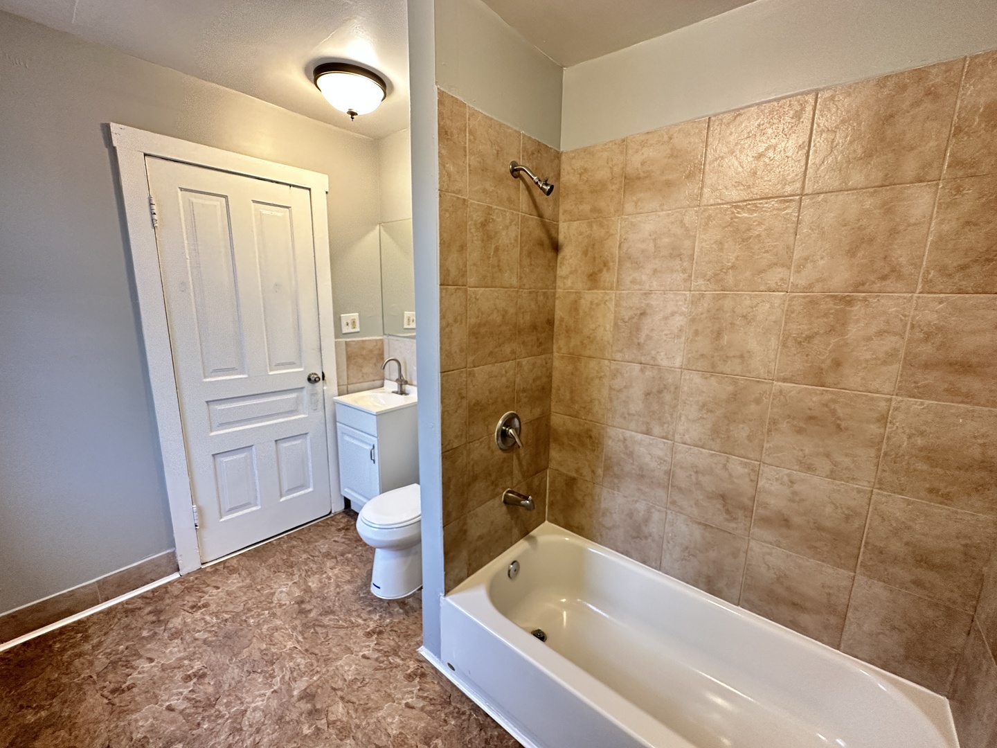 2730 West 16th Street Chicago, IL 60608 - Photo 14 of 14 a bathroom with a granite countertop toilet a sink and bathtub