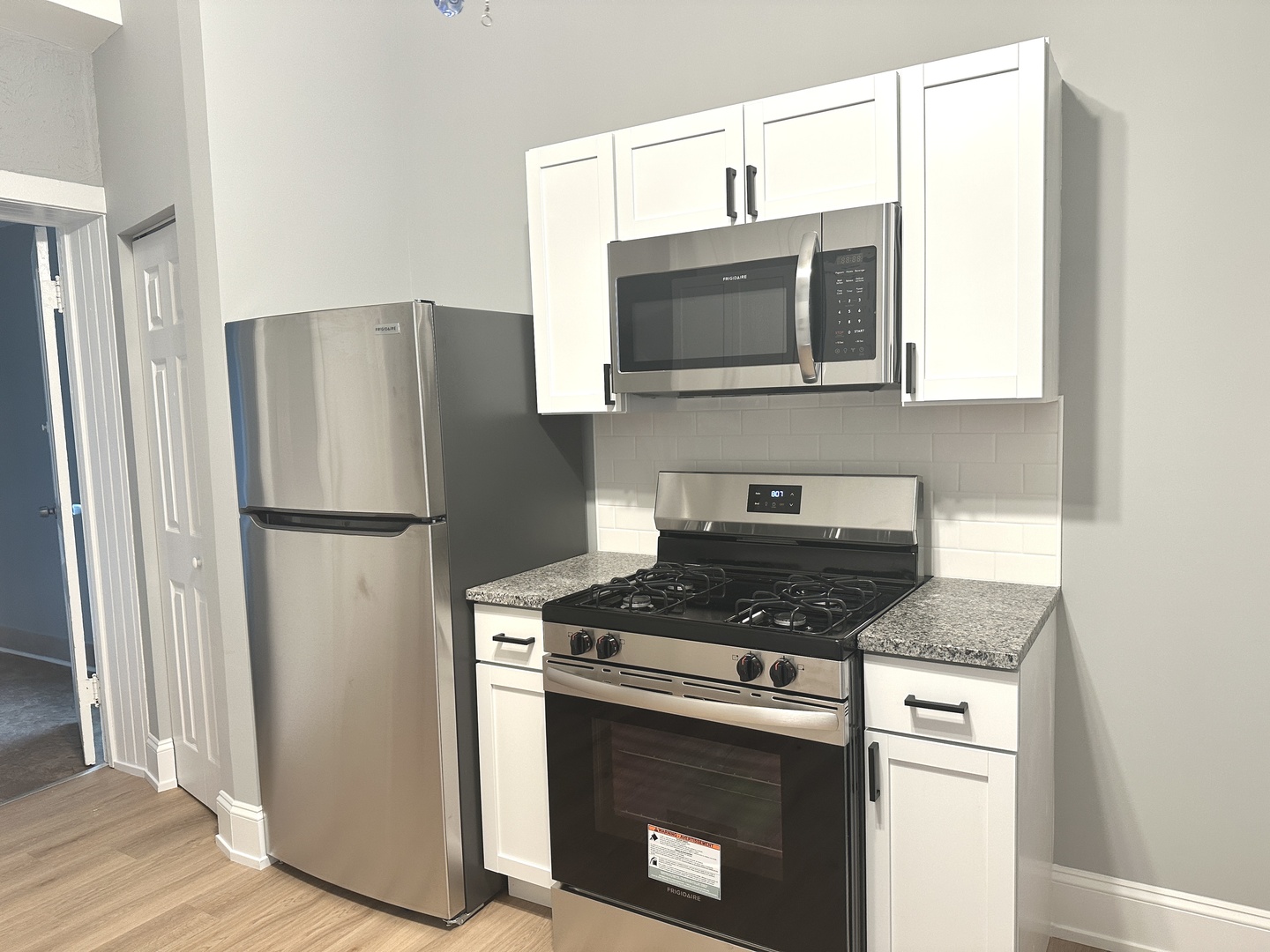 2730 West 16th Street Chicago, IL 60608 - Photo 4 of 14 a kitchen with stainless steel appliances granite countertop a refrigerator stove and microwave