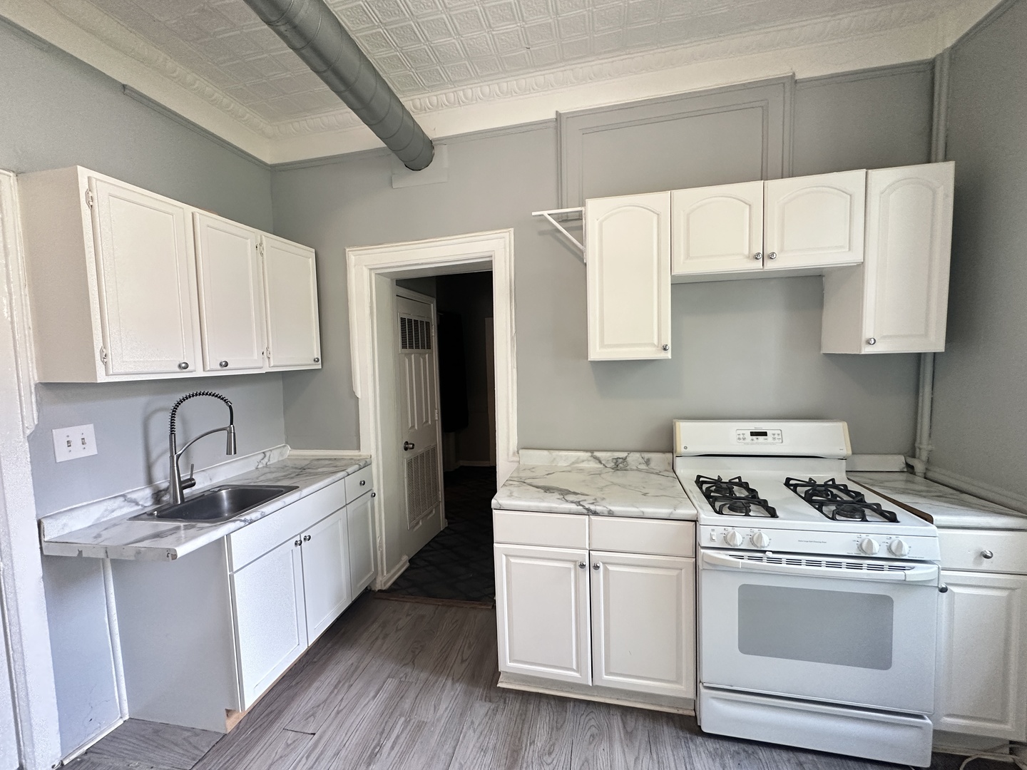 2730 West 16th Street Chicago, IL 60608 - Photo 10 of 14 a kitchen with a sink stove and cabinets