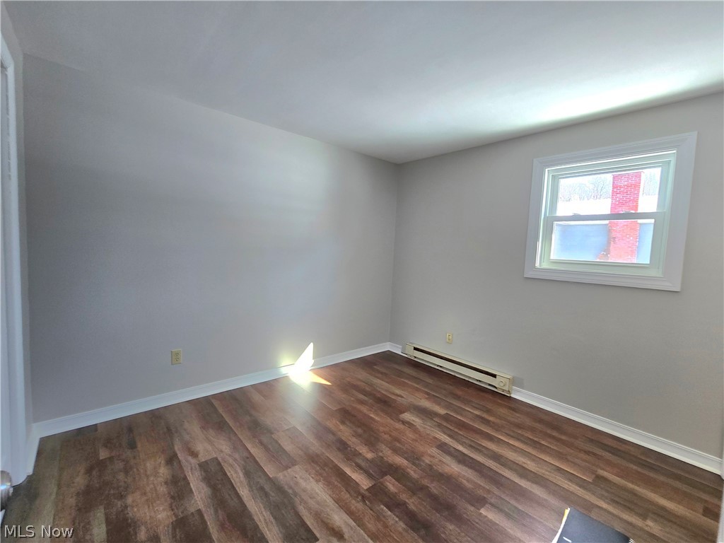 909 Garden Road Zanesville, OH 43701 - Photo 5 of 8 Spare room with a baseboard heating unit and dark wood finished floors