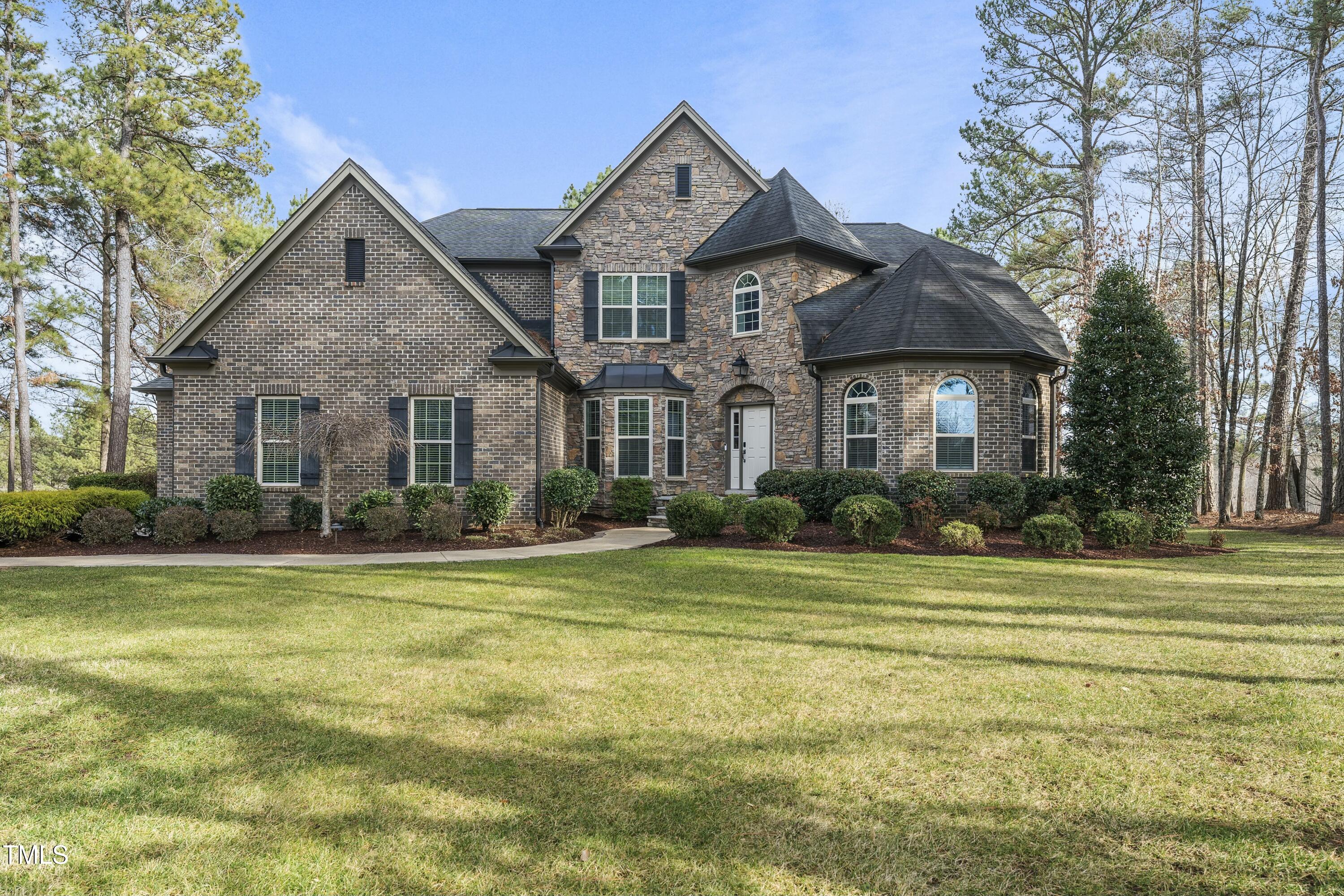 a front view of a house with a yard and trees