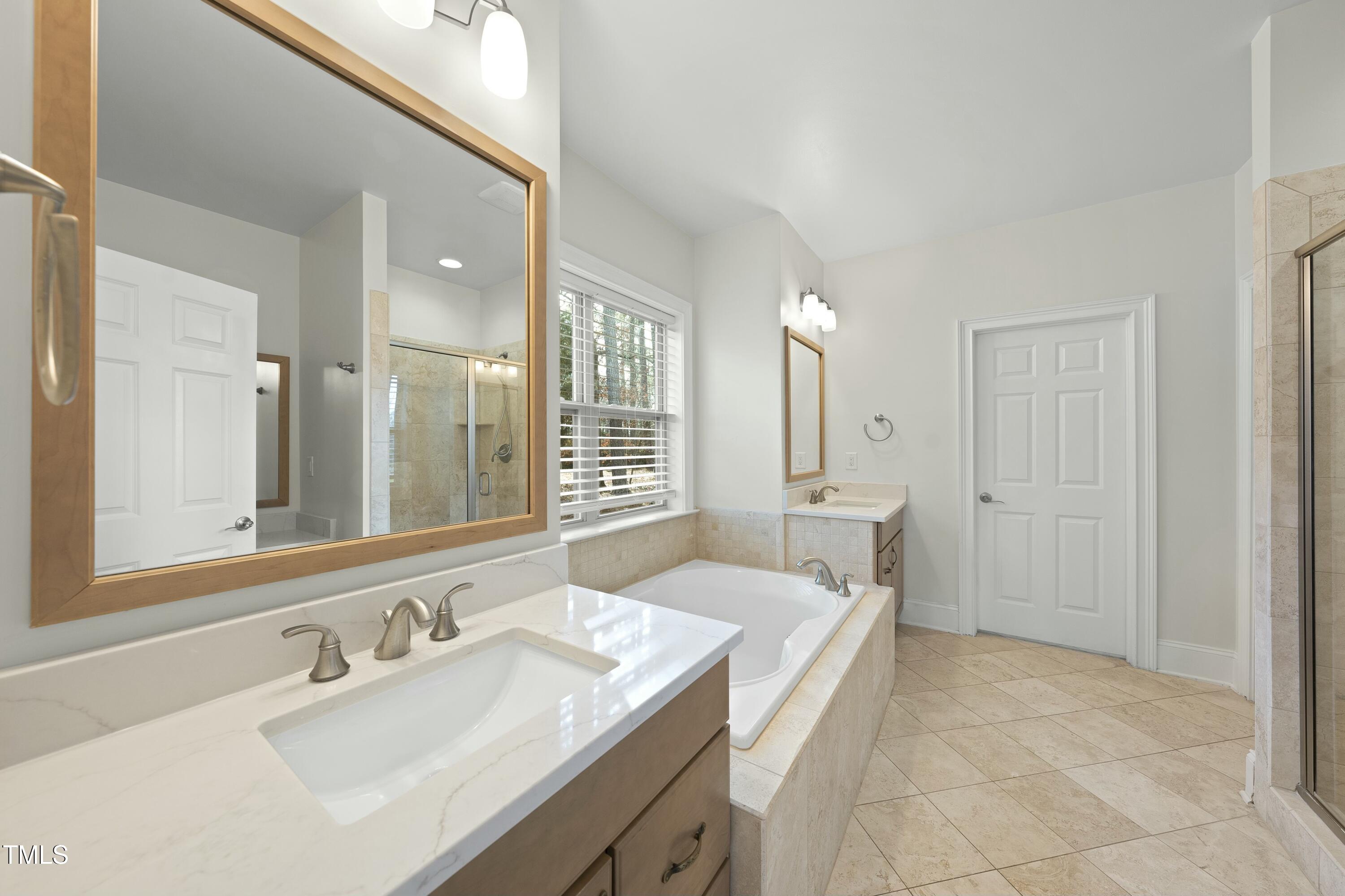 7220 Hasentree Way Wake Forest, NC 27587 - Photo 16 of 39 a spacious bathroom with a granite countertop sink and a mirror