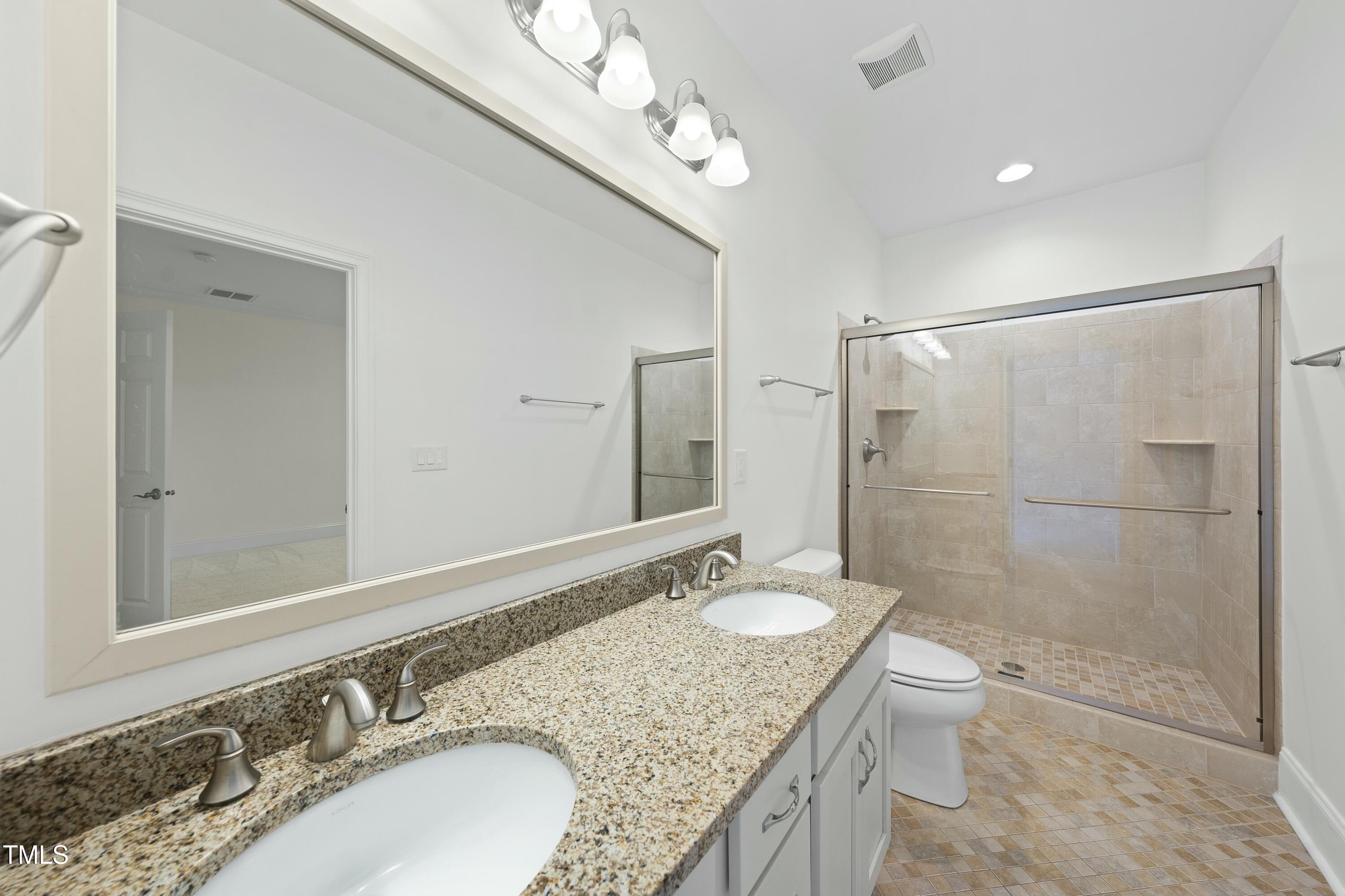 7220 Hasentree Way Wake Forest, NC 27587 - Photo 22 of 39 a bathroom with a granite countertop sink toilet a mirror and shower