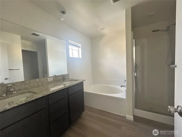 a bathroom with a granite countertop sink mirror and bathtub