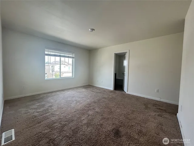 an empty room with windows and closet