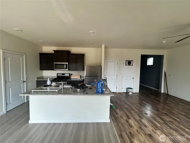 a large white kitchen with wooden floor