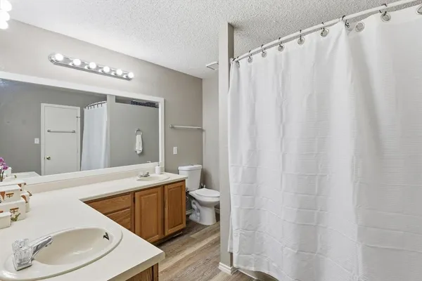 a spacious bathroom with a sink a toilet and shower curtain