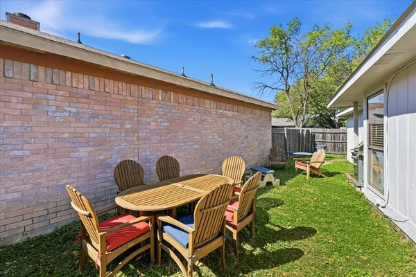 a backyard of a house with table and chairs