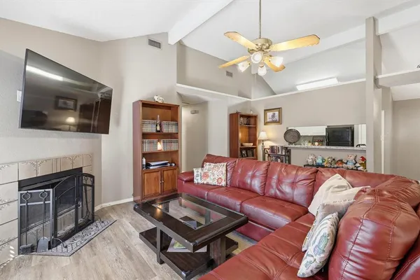 a living room with furniture a flat screen tv and a fireplace