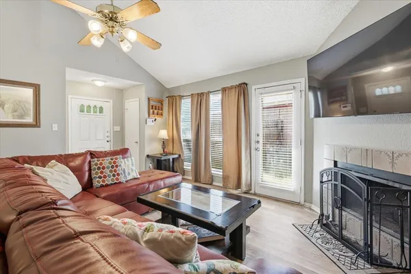 a living room with furniture a fireplace and a flat screen tv