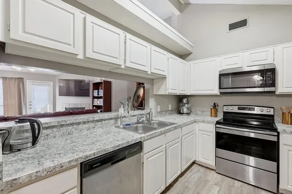 a kitchen with stainless steel appliances granite countertop a sink stove and microwave