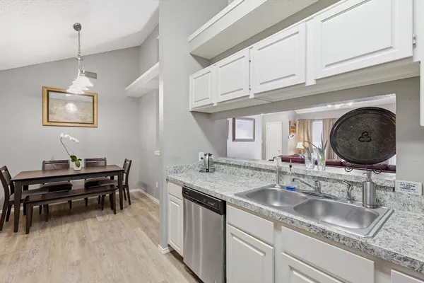 a kitchen with granite countertop a sink a stove and cabinets