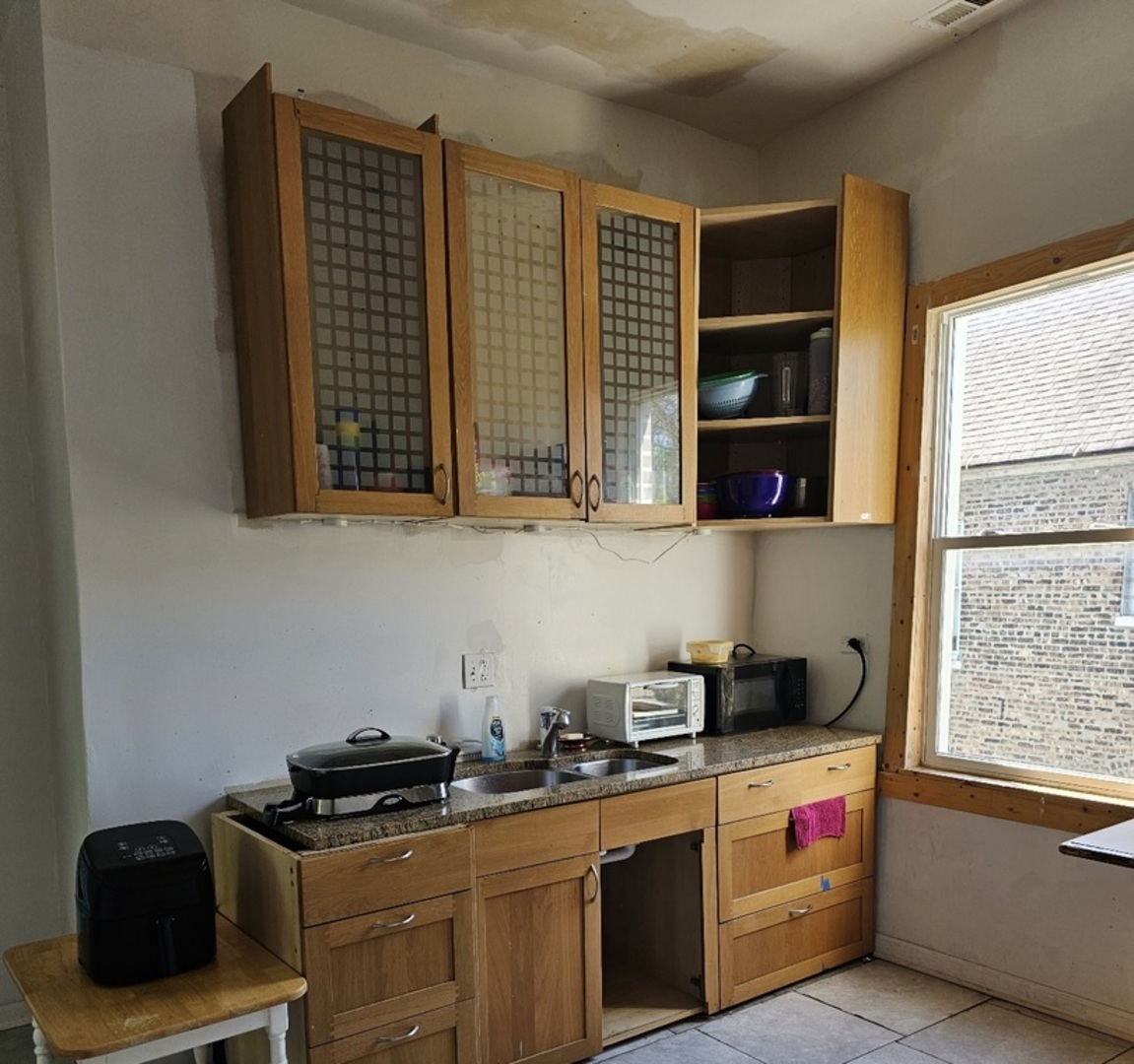 6004 South Aberdeen Street Chicago, IL 60621 - Photo 2 of 17 a kitchen with stainless steel appliances granite countertop a sink and a stove next to a window