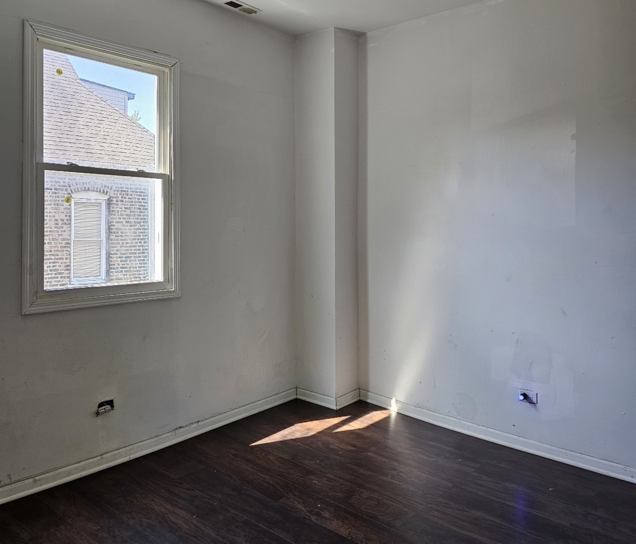 6004 South Aberdeen Street Chicago, IL 60621 - Photo 10 of 17 a view of an empty room with wooden floor and a window