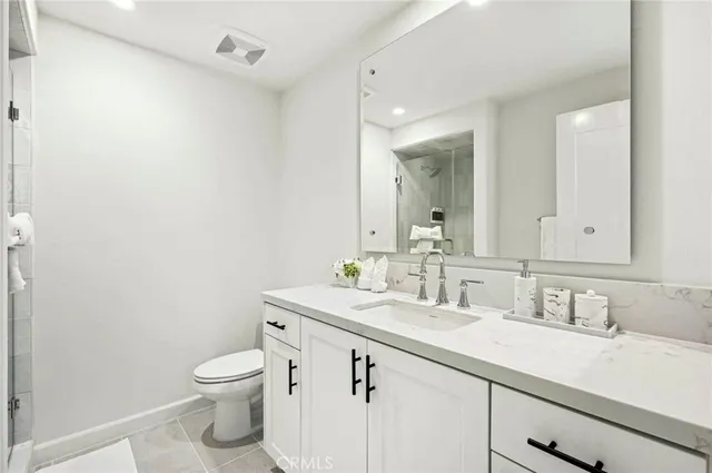 a bathroom with a granite countertop sink a toilet and a mirror