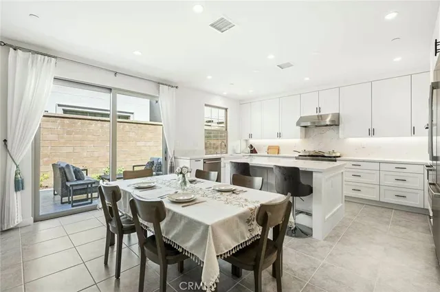 a kitchen with a dining table chairs and white appliances