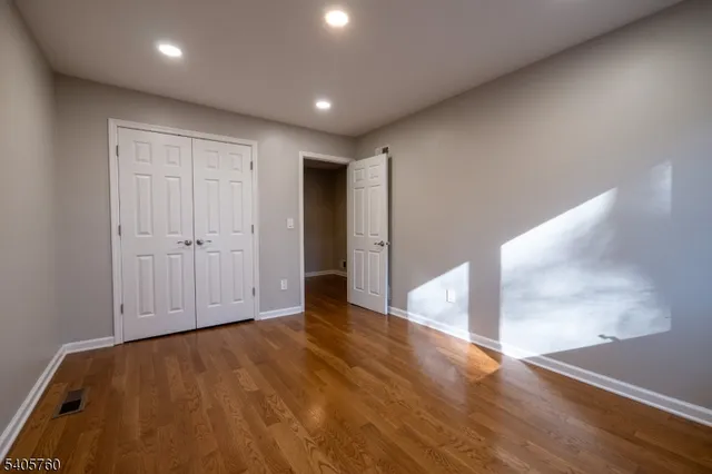an empty room with wooden floor and entryway