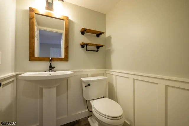 a bathroom with a toilet a sink and mirror