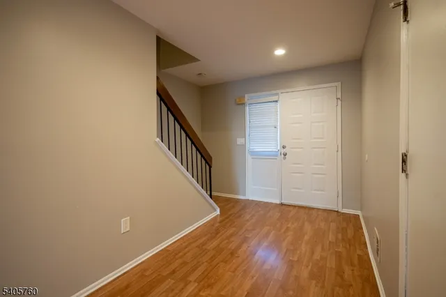 a view of a hallway with wooden floor and staircase
