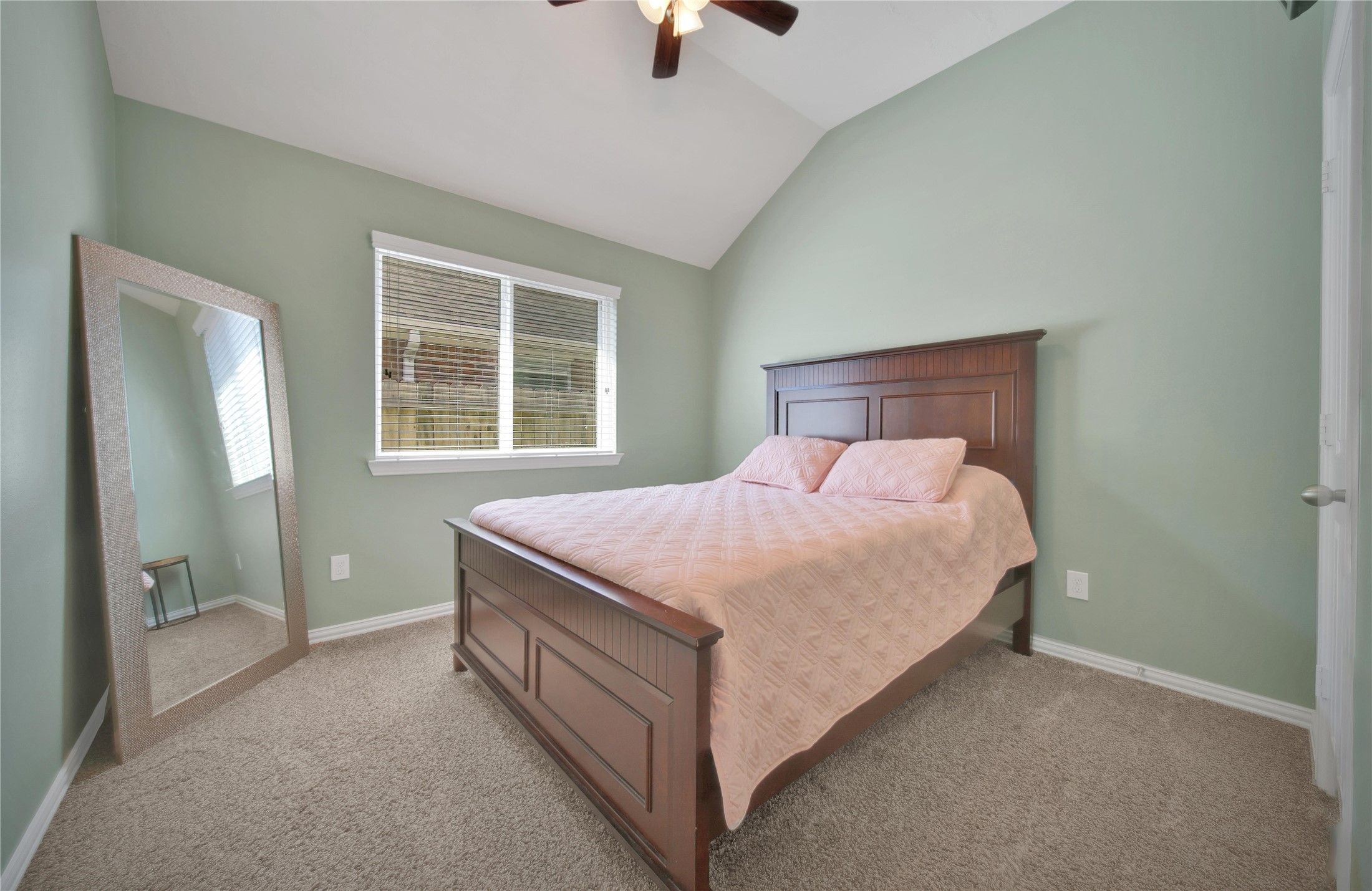 23411 Sawmill Pass Spring, TX 77373 - Photo 17 of 20 a bed sitting in a bedroom next to a window and a chandelier