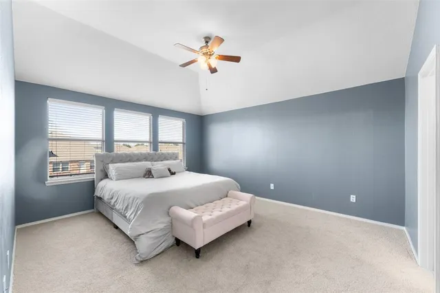 a bedroom with a large bed chandelier and a window