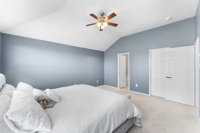 a bedroom with a large bed and a ceiling fan