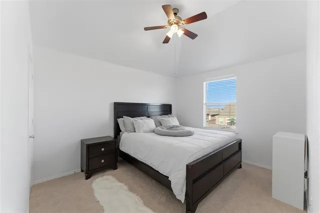 a bedroom with a bed and a ceiling fan