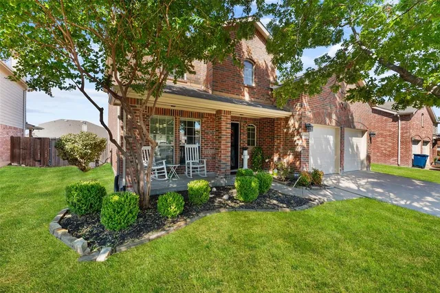 a view of a brick house with a large windows and a large tree