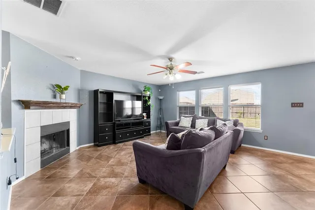 a living room with furniture a flat screen tv and a fireplace