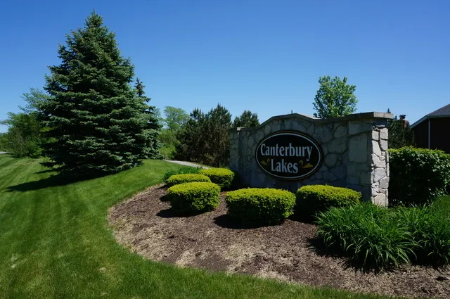 a view of a sign in a yard with potted plants