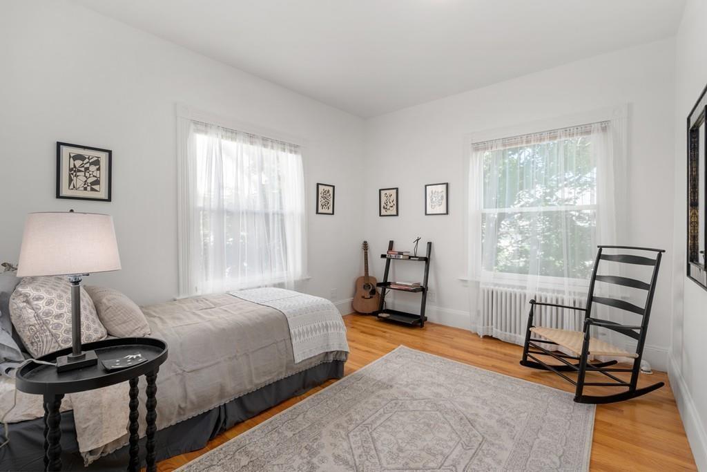 182 Upland Road Cambridge, MA 02140 - Photo 20 of 30 a bedroom with a bed a table and a window