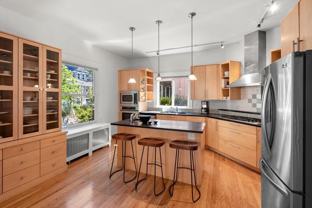 182 Upland Road Cambridge, MA 02140 - Photo 7 of 30 a kitchen with stainless steel appliances granite countertop a refrigerator a sink dishwasher a stove and white countertops with wooden floor