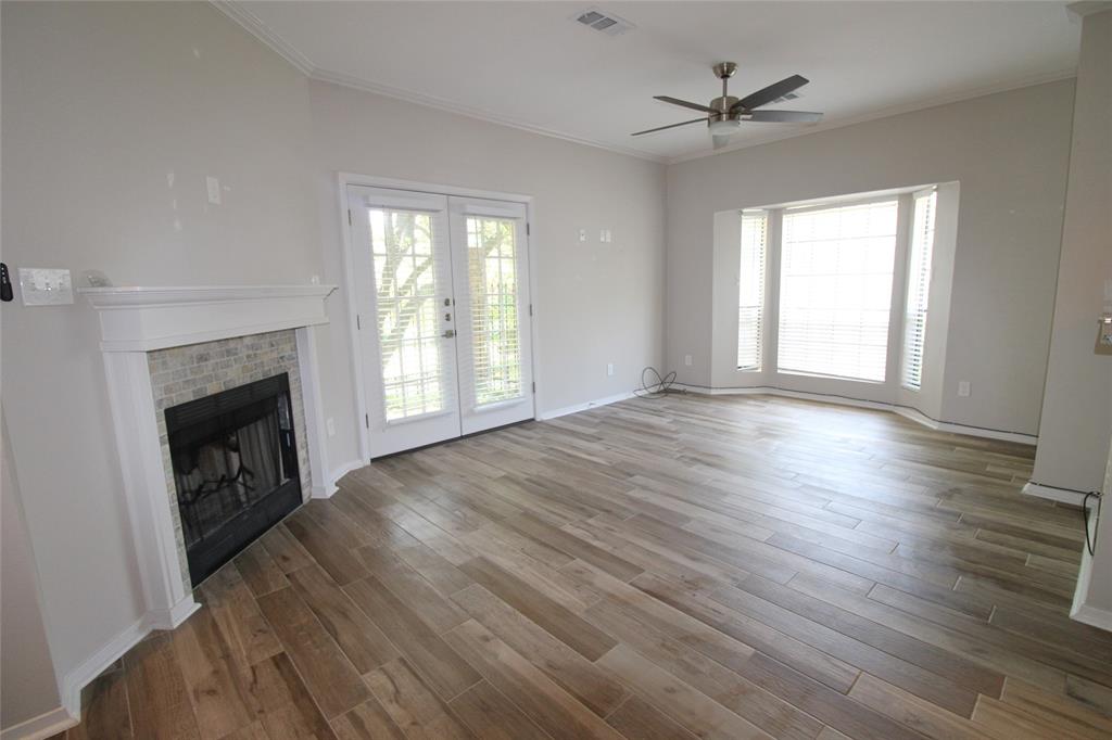 14333 Preston Road, Unit 1304 Dallas, TX 75254 - Photo 12 of 40 an empty room with windows a fireplace and wooden floor