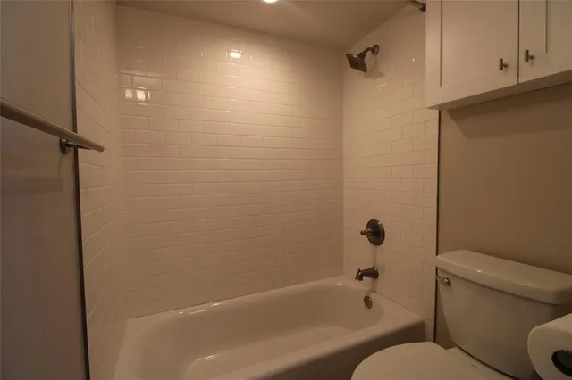 a white toilet sitting next to a bath tub