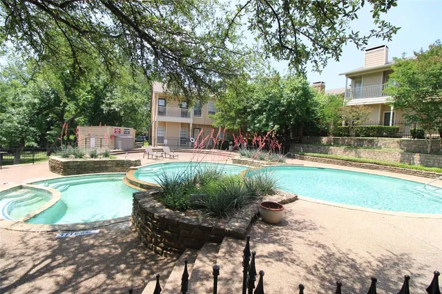 a view of a swimming pool with a patio and plants