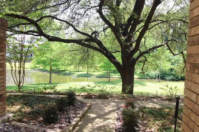 a backyard of a house with lots of green space and fountain