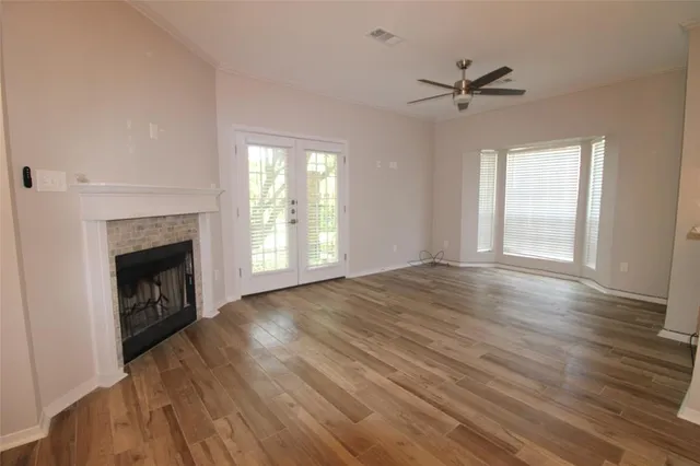 a view of empty room with wooden floor and fireplace