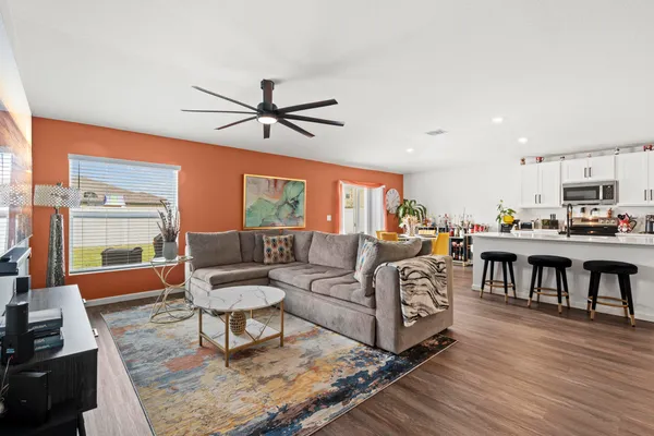 a kitchen with stainless steel appliances granite countertop a table chairs refrigerator and a sink